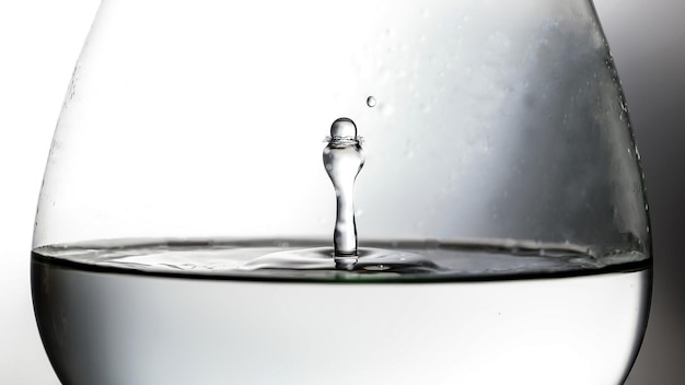 Wassertröpfchen-Tropfen-Splash-Kollision tropfende Säulenreflexion in Brandy-Glas-Brechung