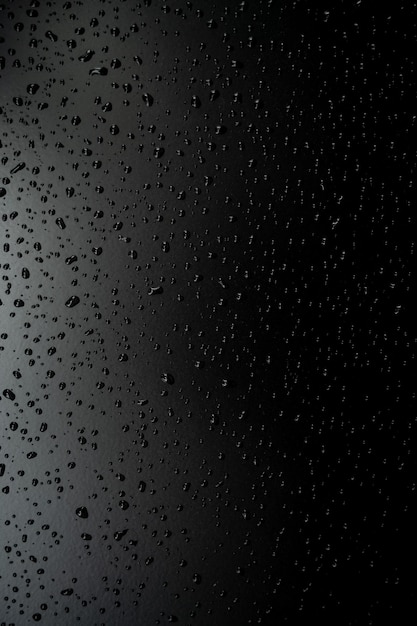 Wassertropfen auf dem Boden mit schwarzem Hintergrund