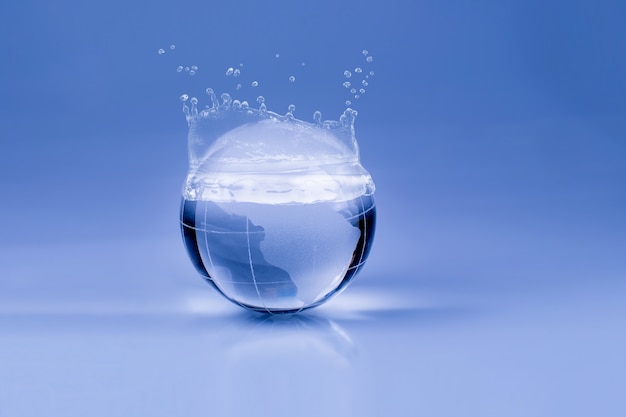 Wassertropfen auf der Glaskugel auf blauem Hintergrund