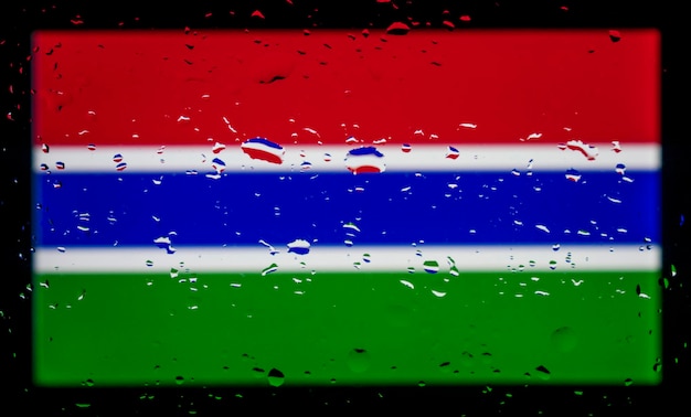 Wassertropfen auf Hintergrund der gambischen Flagge Geringe Schärfentiefe Selektiver Fokus Getönt