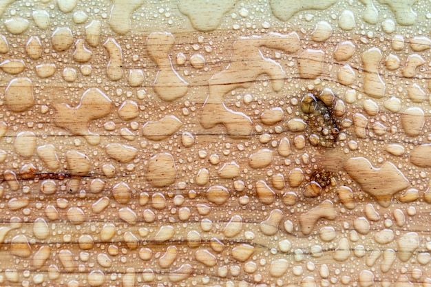 Wassertropfen oder Regentropfen auf Holztischhintergrund