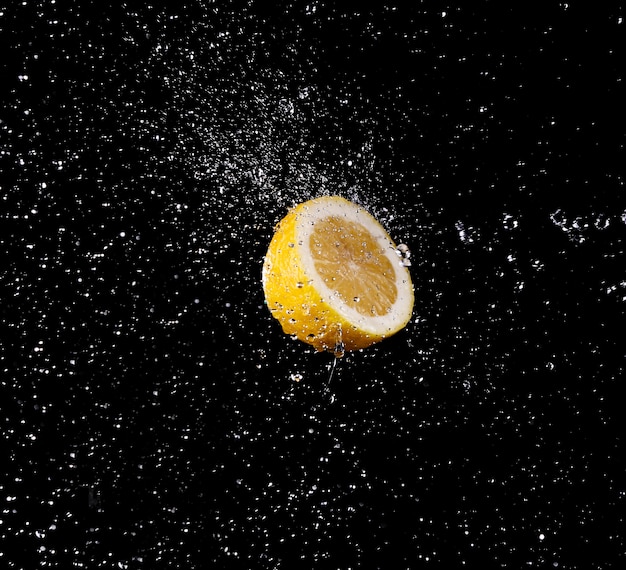 Wassertropfen spritzen auf eine Zitrone