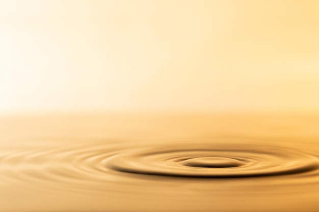 Wassertropfen Transparenter Wassertropfen mit kreisförmigen Wellen Leicht verschwommen goldgelb bespritzt Wassertröpfchen natürliches Wassertropfenkonzept und verwenden Sie es als Hintergrund