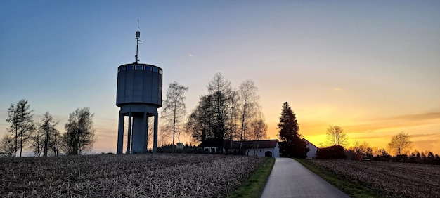 Foto wasserturm und bäume bei sonnenuntergang