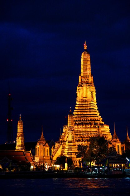 Foto wat arun stupa iluminado por la noche en el paseo marítimo