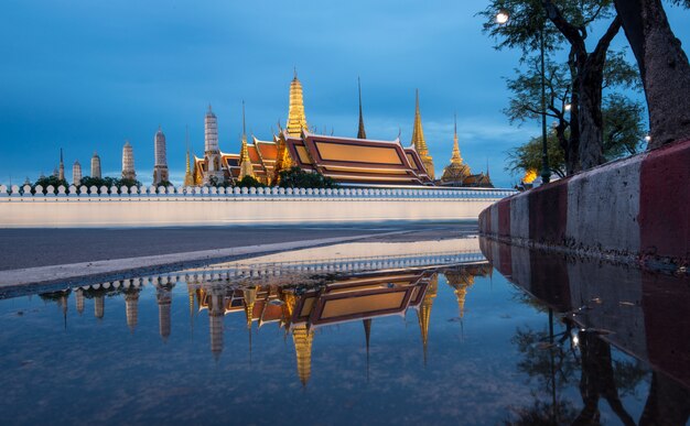 Wat Phra Kaew, palacio magnífico en el crepúsculo en Bangkok, Tailandia con la reflexión.