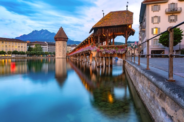 Water Tower, Wasserturm, Mount Pilatus y Chapel Bridge, Kapellbrucke sobre el río Reuss durante la hora azul de la tarde en el casco antiguo de Lucerna, Suiza