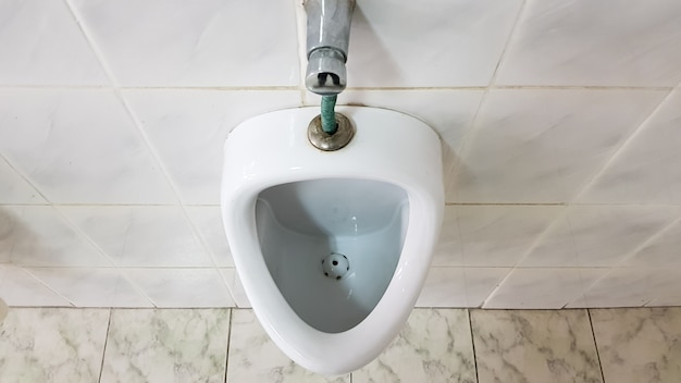 Wc público com um urinol cerâmico. Os mictórios preparam tigelas para os homens.