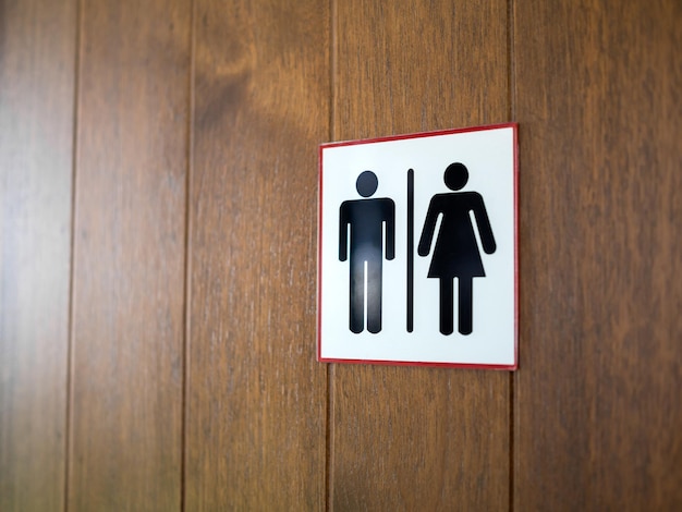 WC-Toilettenzeichen-Mann- und Damenikone auf hölzernem Hintergrund Auch im corel abgehobenen Betrag