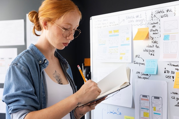 Web designer feminina com papéis e notas no escritório
