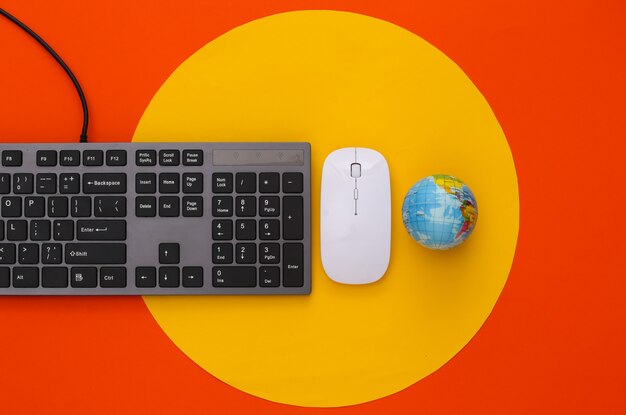 Web global. Teclado de PC con mouse de PC, globo en naranja con círculo amarillo
