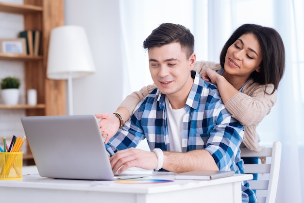 Web mundial. Pareja amorosa positiva mirando la pantalla mientras el hombre escribe