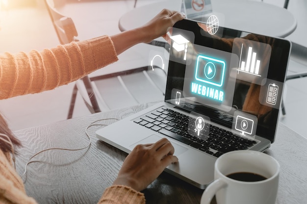 Webinar capacitación en aprendizaje electrónico concepto de tecnología de Internet de negocios Persona que utiliza una computadora portátil y un teléfono inteligente con icono de webinar de pantalla VR en el escritorio de la oficina