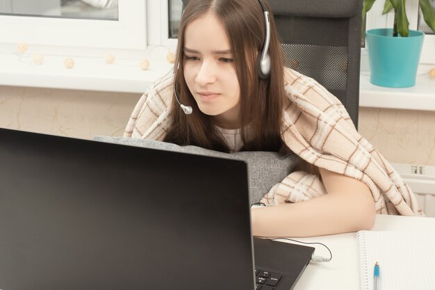 Webinar. Chica en auriculares con un micrófono frente a una computadora portátil