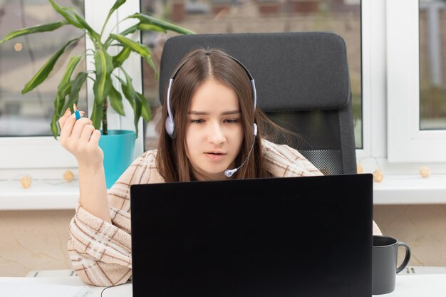 Webinar de educação online A menina ouve uma palestra sobre comunicação por vídeo em casa