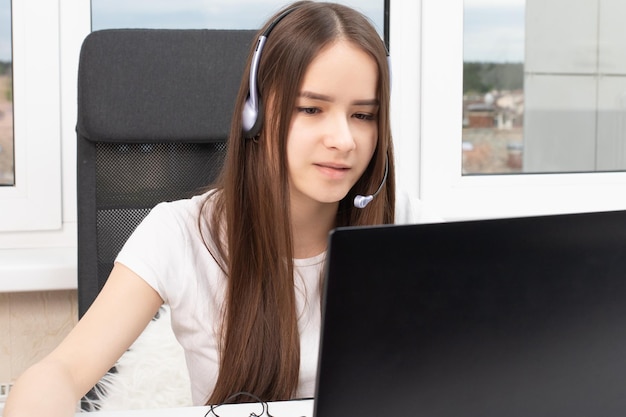 Webinar Mädchen mit Kopfhörern und Mikrofon vor einem Laptop