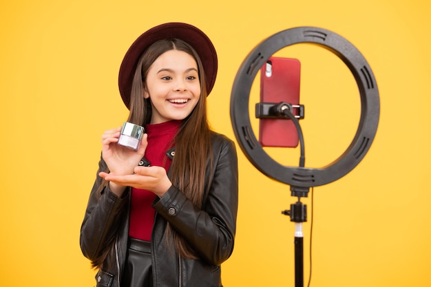 Weblog und Vlog. Make-up Anleitung. Beeinflusser. glückliches Teenie-Mädchen verwenden Selfie-LED. Kinderschönheitsblogger. Kindheitsglück. fröhliches Kind schminken. Vlogger mit Kosmetik. Erstellen Sie einen Videoblog auf dem Smartphone.