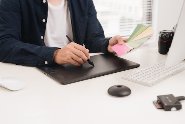 Website-Designer, der digitales Tablet und Computer-Laptop am Schreibtisch arbeitet