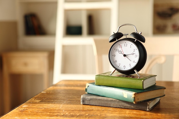 Wecker auf Büchern am Tisch