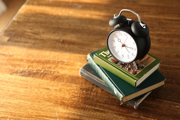 Wecker auf den Büchern am Tisch