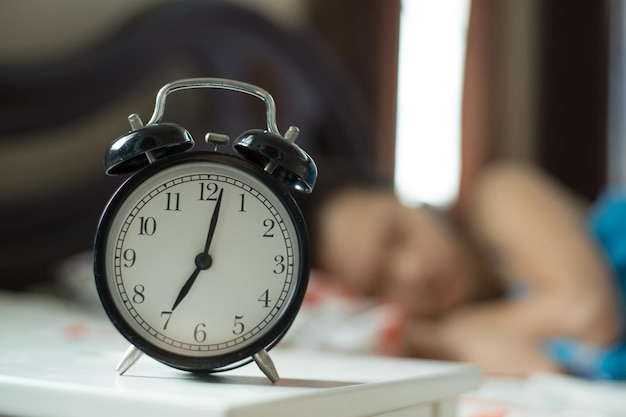 Wecker, Frau faul aufzuwachen, um auf dem Bett zu arbeiten.