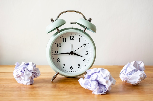 Foto wecker mit zerknitterten papierbällen timing und denkendes ideenkonzept