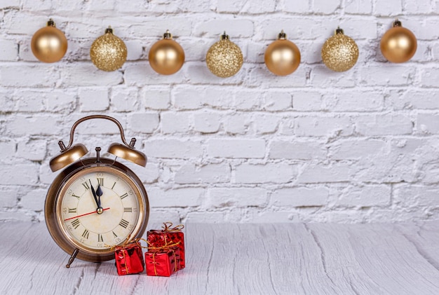 Wecker Weihnachtsbaumgeschenke Weihnachtsspielzeug auf dem Hintergrund einer Backsteinmauer