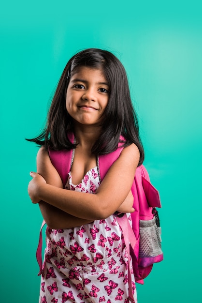 Weg zum Schulkonzept - Nettes kleines indisches Mädchen, das mit Schultasche steht, einzeln auf grünem Hintergrund