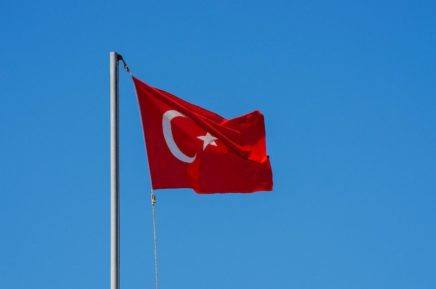 Wehende Flagge der Türkei unter sonnigem blauem Himmel