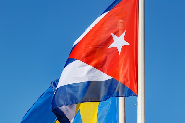 Wehende Nationalflagge der Republik Kuba vor blauem Himmelshintergrund