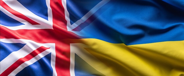 Wehendes Flaggenkonzept der Ukraine und Großbritanniens, das die politische Verbindung symbolisiert