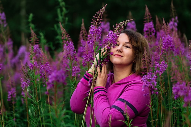 Weibchen im Hoodie inmitten von Blumen auf der Wiese