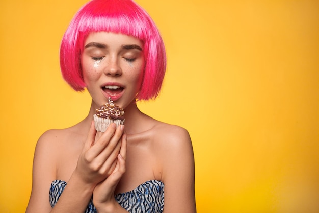 Weibchen in rosa Perücke mit Cupcake