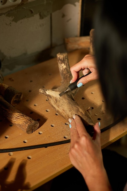 Weibchen mit Power-Holzbearbeitungswerkzeugen Graver Schnitzen beim Basteln