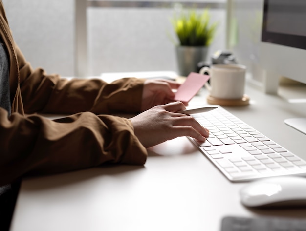 Foto weibliche arbeit mit computergerät beim suchen einer idee auf notizblock auf weißem schreibtisch