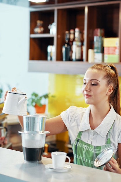 Weibliche Barista, die Kaffee kocht