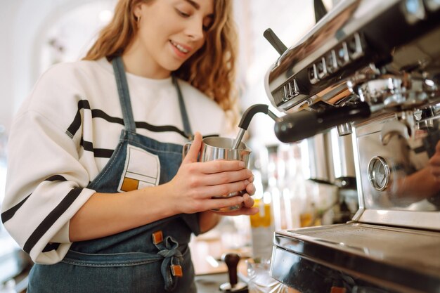 Weibliche Barista kocht Kaffee in einer Kaffeemaschine Konzeption von Geschäft und Service Essen zum Mitnehmen