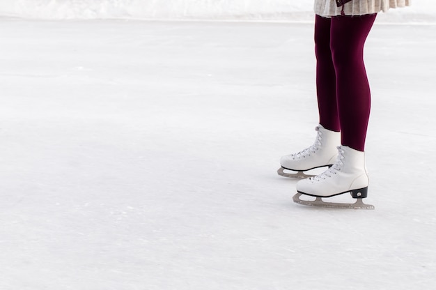 Weibliche beine auf schlittschuhen auf einer eisbahn