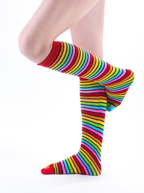 Weibliche Beine in bunt gestreiften Socken isoliert auf weiß