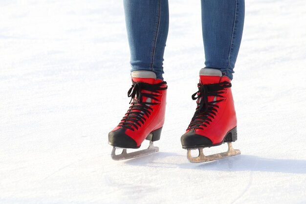 Weibliche Beine in Schlittschuhen auf einer Eisbahn