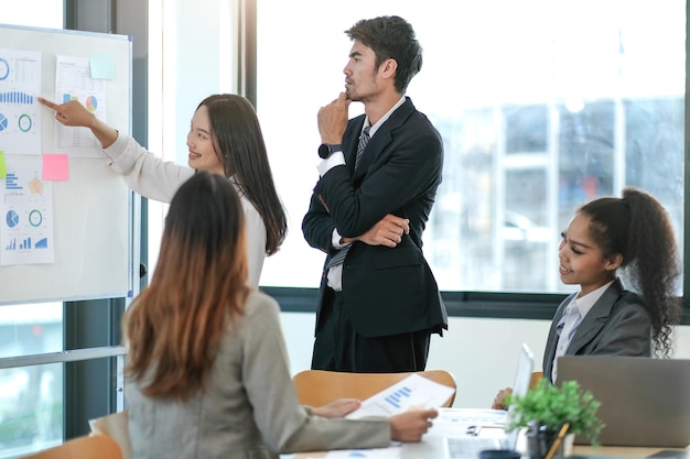 Weibliche Betriebsleiterin hält Meeting-Präsentation für ein Team von Wirtschaftswissenschaftlern Asiatin verwendet digitales Whiteboard mit Wachstumsanalysediagrammen Statistiken und Daten Menschen arbeiten im Geschäftsbüro