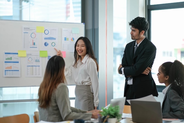 Weibliche Betriebsleiterin hält Meeting-Präsentation für ein Team von Wirtschaftswissenschaftlern Asiatin verwendet digitales Whiteboard mit Wachstumsanalysediagrammen Statistiken und Daten Menschen arbeiten im Geschäftsbüro