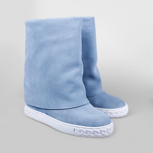 Weibliche blaue Stiefel über Weiß