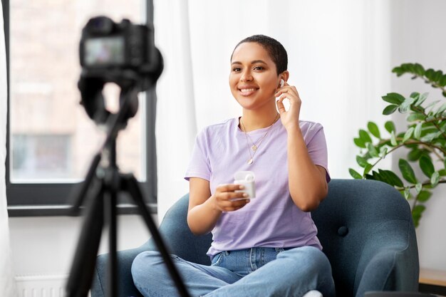 weibliche Bloggerin mit Kamera, die zu Hause videobloggt