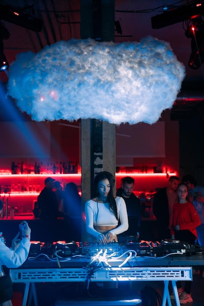 Foto weibliche dj spielt musik in einem nachtclub oder bei anderen veranstaltungen mit dj-ausrüstung