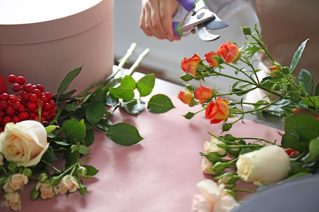 Weibliche Floristenhände, die Zusammensetzung mit Blumennahaufnahme machen