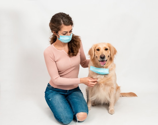 Weibliche Frau und Hund in medizinisch geschützter Gesichtsmaske