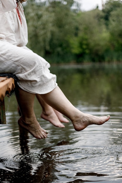 Weibliche Füße, die im Flusswasser planschen