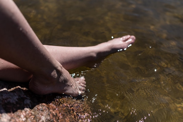 Weibliche Füße im Seewasser