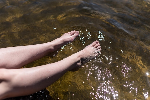 Weibliche Füße im Seewasser